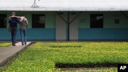 American Pastor Kenton Moody, left, walks arm in arm with a young man who was in prison for belonging to a gang, during a break on the grounds of the “Vida Libre” or “free life,” rehabilitation center, in Santa Ana, El Salvador, April 29, 2023. 