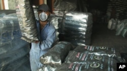 FILE - A worker carries a bag of charcoal, believed to be from Somalia, to deliver it to a customer at a charcoal trading facility in Sharjah, United Arab Emirates, Nov. 28, 2013. Image taken from AP Television.