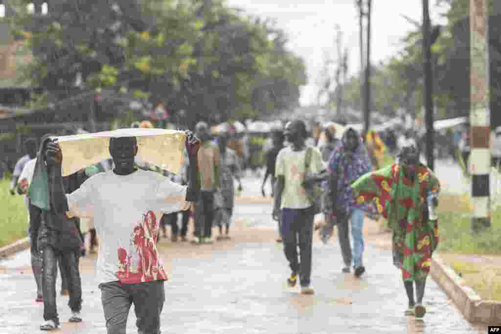 Pessoas deslocadas da província de Cabo Delgado caminham pelas ruas de Namapa, distrito de Erati, em Nampula, Moçambique, a 27 de fevereiro de 2024.