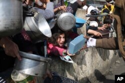 Warga Palestina antre untuk mendapatkan makanan gratis selama serangan udara dan darat Israel yang sedang berlangsung di Rafah, Jalur Gaza, 9 Januari 2024. (AP Photo/Hatem Ali)