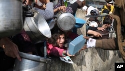 Palestinians line up for free food during the ongoing Israeli air and ground offensive on the Gaza Strip, in Rafah, Jan. 9, 2024.