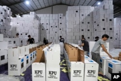 Para pekerja menata kotak suara saat persiapan pendistribusian logistik pemilu di Tangerang, provinsi Banten, 10 Januari 2024. (Foto: Tatan Syuflana/AP Photo)