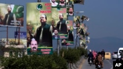 Motorcyclists and cars drive past welcoming banners for Pakistan's self-exiled former prime minister Nawaz Sharif, installed along a highway in Rawalpindi, Pakistan, Oct. 19, 2023. 