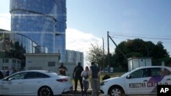 Servicemen speak to a journalist near the office building of the Wagner Private Military Company associated with Yevgeny Prigozhin, in St. Petersburg, Russia, June 24, 2023.
