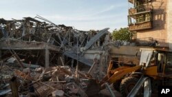 A tractor clears the rubble after a Russian strike on the Sapphire hotel in Kramatorsk, Donetsk region, Ukraine, Aug. 25, 2024. 