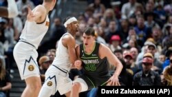 Pemain Minnesota Timberwolves Luka Garza (nomor seragam 55) berusaha keluar dari sergapan pebasket Denver Nuggets Zeke Nnaji (22) dalam pertandingan liga bola basket NBA di Denver, pada 18 Januari 2023. (Foto: AP/David Zalubowski)