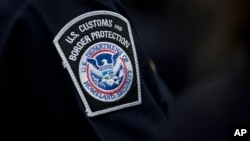 FILE - A customs agent wears a patch for the U.S. Customs and Border Protection agency at John F. Kennedy International Airport in New York, Oct. 27, 2017.