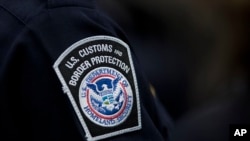 FILE - A customs agent wears a patch for the U.S. Customs and Border Protection agency at John F. Kennedy International Airport in New York, Oct. 27, 2017.