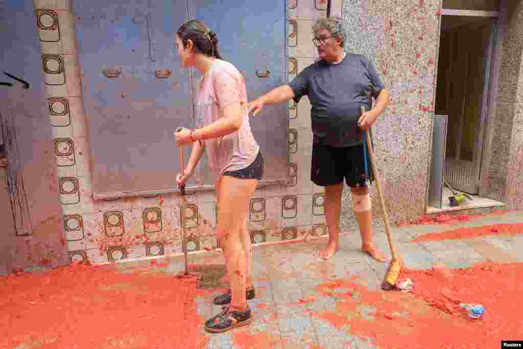  Moradores locais limpam a polpa de tomate após o festival anual de luta de alimentos &ldquo;La Tomatina&rdquo; em Bunol, perto de Valência, Espanha, 28 de agosto de 2024. &nbsp; 