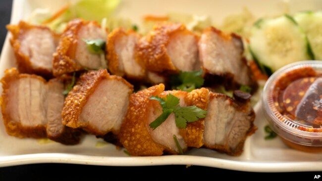 FILE - Crispy pork belly is presented at Love & Thai restaurant in Fresno, Calif. on Dec. 20, 2023.