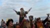 Un hombre vestido como uno de los Tres Reyes saluda a la gente durante el desfile de la Epifanía en Gijón, España.