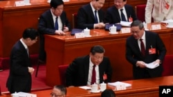 中國領導人習近平、總理李強和全國政協主席王滬寧在人大會堂進行的全國人大會議上。（2024年3月5日）