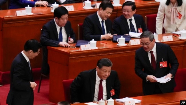 中国领导人习近平、总理李强和全国政协主席王沪宁在人大会堂进行的全国人大会议上。(2024年3月5日)