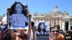 People hold placards with Emanuela Orlandi's portrait at the end of Pope's Angelus prayer in St. Peter's Square at the Vatican, June 25, 2023.
