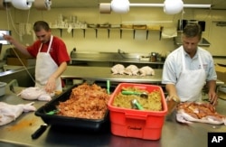 FILE - Glenn Mistich, right, and Justin Brand create turduckens, a Louisiana specialty that is a turkey stuffed with a chicken and a duck, at the Gourmet Butcher Block in Gretna, Louisiana, Nov. 20, 2005. Dressing is added between each layer.
