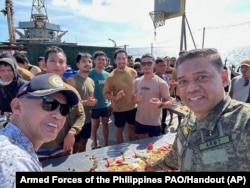 Philippine military chief, General Brawner, right, shares a meal with Filipino marines and navy personnel stationed aboard the long-marooned BRP Sierra Madre at the Second Thomas Shoal at the disputed South China Sea, Dec. 10, 2023.