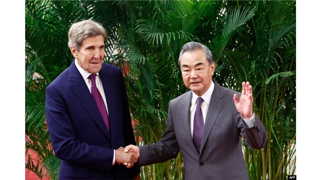 FILE - US Climate Envoy John Kerry and Director of the Office of the Foreign Affairs Commission of the Communist Party of China's Central Committee Wang Yi shake hands before a meeting at the Great Hall of the People in Beijing, July 18, 2023.