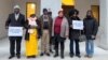 Plaintiffs pose at the entrance of the Swiss Federal Criminal Court during the opening day of the trial of Ousman Sonko, January 8, 2024.