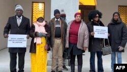 FILE — Plaintiffs pose at the entrance of the Swiss Federal Criminal Court, on January 8, 2024 in Bellinzona, southern Switzerland at the opening day of the trial of Ousman Sonko, a Gambian former interior minister accused of crimes against humanity.