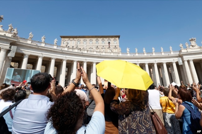 Faithful gathered for the traditional Sunday noon blessing in St. Peter's Square at The Vatican cheers at Pope Francis appearing at his studio's window, Sunday, Oct. 1, 2023. (AP Photo/Riccardo De Luca)