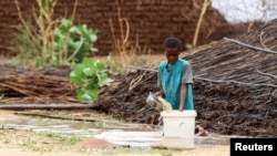 FILE - A displaced Sudanese child pours water at Zamzam camp, in North Darfur, Sudan, Aug. 1, 2024.