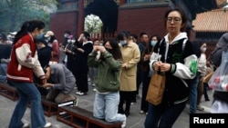 中國年輕人到北京一間寺廟燒香祈福。（2023年4月22日）