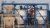 FILE - A worker at Mukuyu 2 prepares for oil and gas exploration at the Invictus mine in Mbire district in Mashonaland Central province north of the Zimbabwean capital of Harare, Sept. 13, 2023.