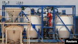 FILE - A worker at Mukuyu 2 prepares for oil and gas exploration at the Invictus mine in Mbire district in Mashonaland Central province north of the Zimbabwean capital of Harare, Sept. 13, 2023.