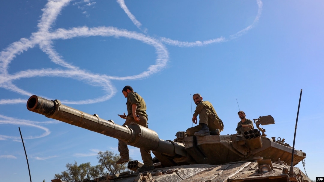 Israeli troops stand atop a tank on the border with the Gaza Strip on Nov. 30, 2023, on the seventh day of a truce in battles between Israel and Hamas militants.