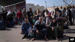 Palestinians wait to cross into Egypt at the Rafah border crossing in the Gaza Strip on Oct. 16, 2023.