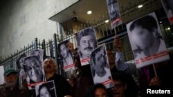 Periodistas y activistas sostienen imágenes de comunicadores asesinados durante una protesta en México el 10 de julio de 2023.