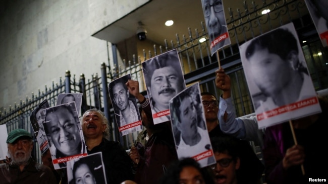Periodistas y activistas sostienen imágenes de comunicadores asesinados durante una protesta en México el 10 de julio de 2023.