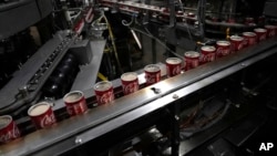 Coca-Cola cans move down a conveyer belt in the Swire Coca-Cola bottling plant Oct. 20, 2023, in Denver. (AP Photo/Brittany Peterson)