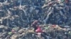 FILE — A man searches for food among garbage in Tegucigalpa, Honduras, Nov. 30, 2023. As many as 783 million people around the world suffer from hunger, Action Against Hunger, an international organization, said on Tuesday. 