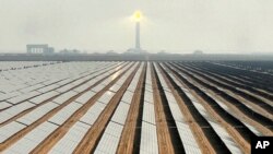 FILE - Solar panels at Mohammed bin Rashid Al Maktoum Solar Park and its solar tower are visible, in Dubai, United Arab Emirates, Nov. 9, 2023.