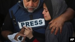 Al Jazeera journalist Wael Dahdouh holds the hand of his son Hamza, who also worked for Al Jazeera and who was killed in an Israeli airstrike in Rafah, Gaza Strip, Jan. 7, 2024.