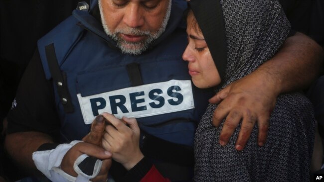 Al Jazeera journalist Wael Dahdouh holds the hand of his son Hamza, who also worked for Al Jazeera and who was killed in an Israeli airstrike in Rafah, Gaza Strip, Jan. 7, 2024.