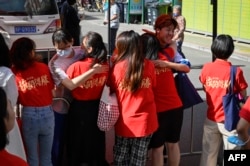 Students hug their teachers before entering the school on the first day of China's national college entrance examination in Beijing, June 7, 2023.