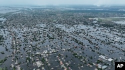 ARCHIVO - Las casas están sumergidas en la ciudad de Oleshky, Ucrania, el 10 de junio de 2023, debido a la destrucción de la represa Kakhovka en junio, en el río Dnipro en Ucrania.