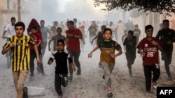 Palestinian children run as they flee from Israeli bombardment in Rafah in the southern Gaza Strip on Nov. 6, 2023.