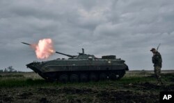 FILE - A Ukrainian armored personnel carrier fires toward Russian positions near Avdiivka, Donetsk region, April 28, 2023. Ukrainian soldiers told Reuters in early November 2023 that Russian artillery has intensified in the region in recent weeks.