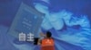 一名工人在上海举办的世界人工智能大会上检查中国科技公司中科曙光展示的芯片和自主字样的屏幕。（2023年7月5日）