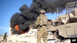 In this image taken from a video released by the Israel Defense Forces on Nov. 14, 2023, an Israeli soldier holds a weapon in Gaza City.