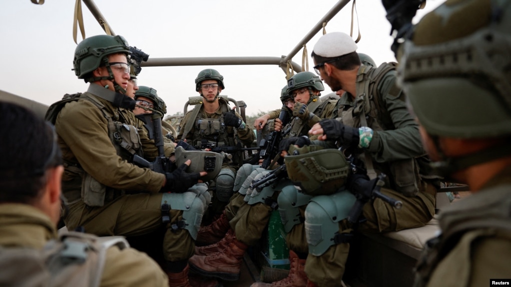 이스라엘군 장병들이 4일 남부 가자지구 접경 인근에서 군용차량에 탑승하고 있다.