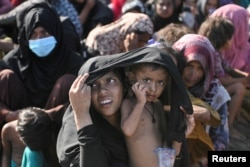 Sejumlah perempuan Muslim Rohingya saat beristirahat di pantai setibanya di Blang Raya, Pidie, Aceh, 10 Desember 2023. (Foto: Reuters)