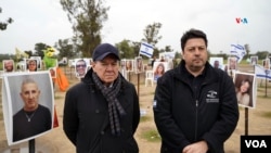 Los argentinos Daniel Alaluf (der), residente en Israel y Mario Montoto (izq) posan en el memorial erigido en recuerdo de los más de 340 jóvenes asesinados en Re'im, durante el ataque de Hamás al festival de música elctrónica Nova.