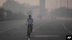 Un ciclista viaja en medio del smog en Nueva Delhi, India, el martes 7 de noviembre de 2023. Las máscaras están de vuelta en las calles mientras los residentes de la capital luchan contra el aumento anual de la contaminación del aire que ha afectado a la región.