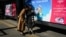 FILE - Two women look at a mobile phone in front of billboards at a bus stop in Beijing, China, Nov. 11, 2023.