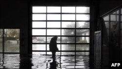 A garage owner walks in his flooded garage in Longfosse, northern France.