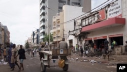 People stand at the entrance of a destroyed supermarket in Dakar, Senegal, June 3, 2023. 